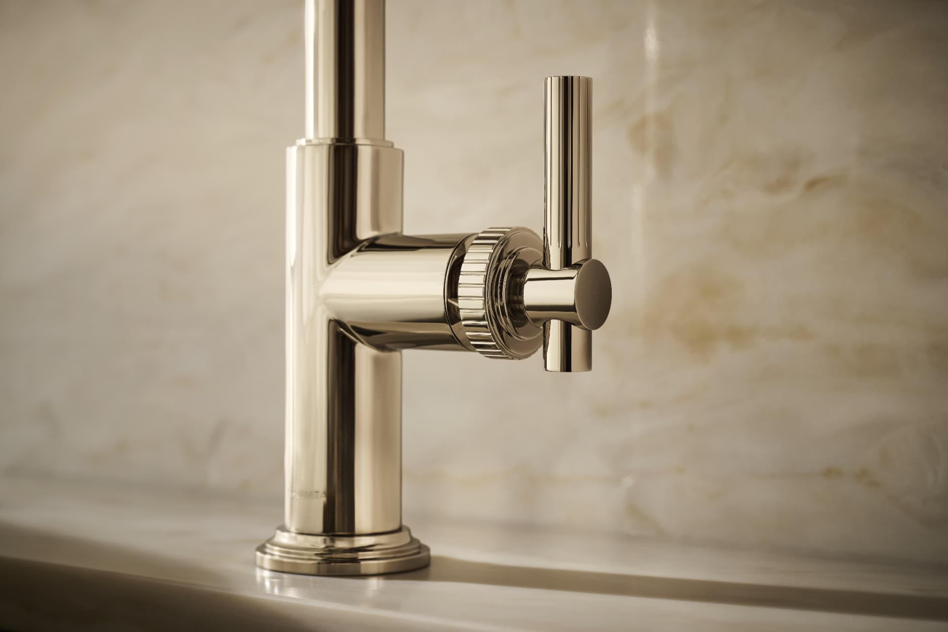 Close detail of a polished nickel faucet handle against onyx