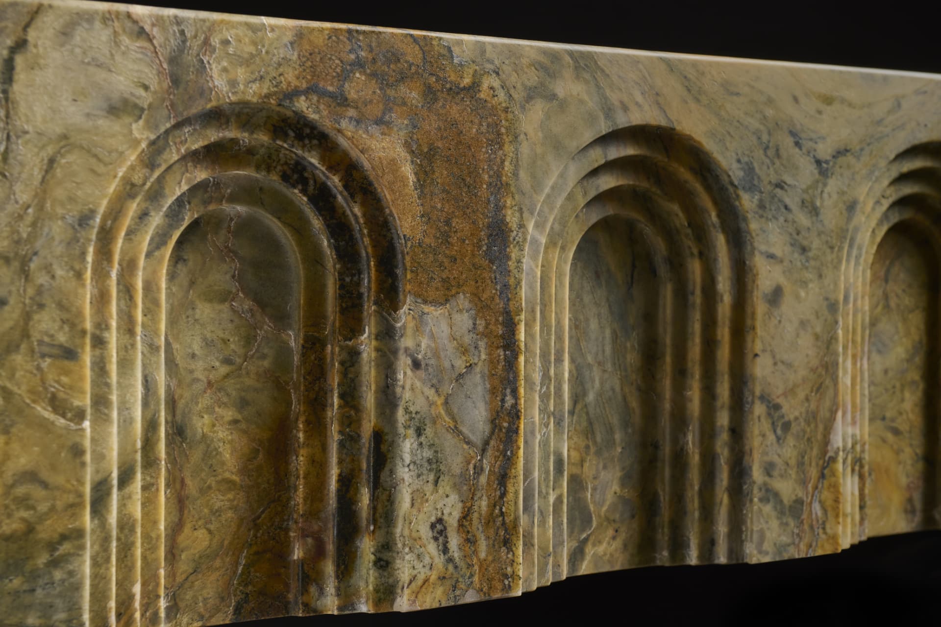 Carved stone arches with warm veined marble detail