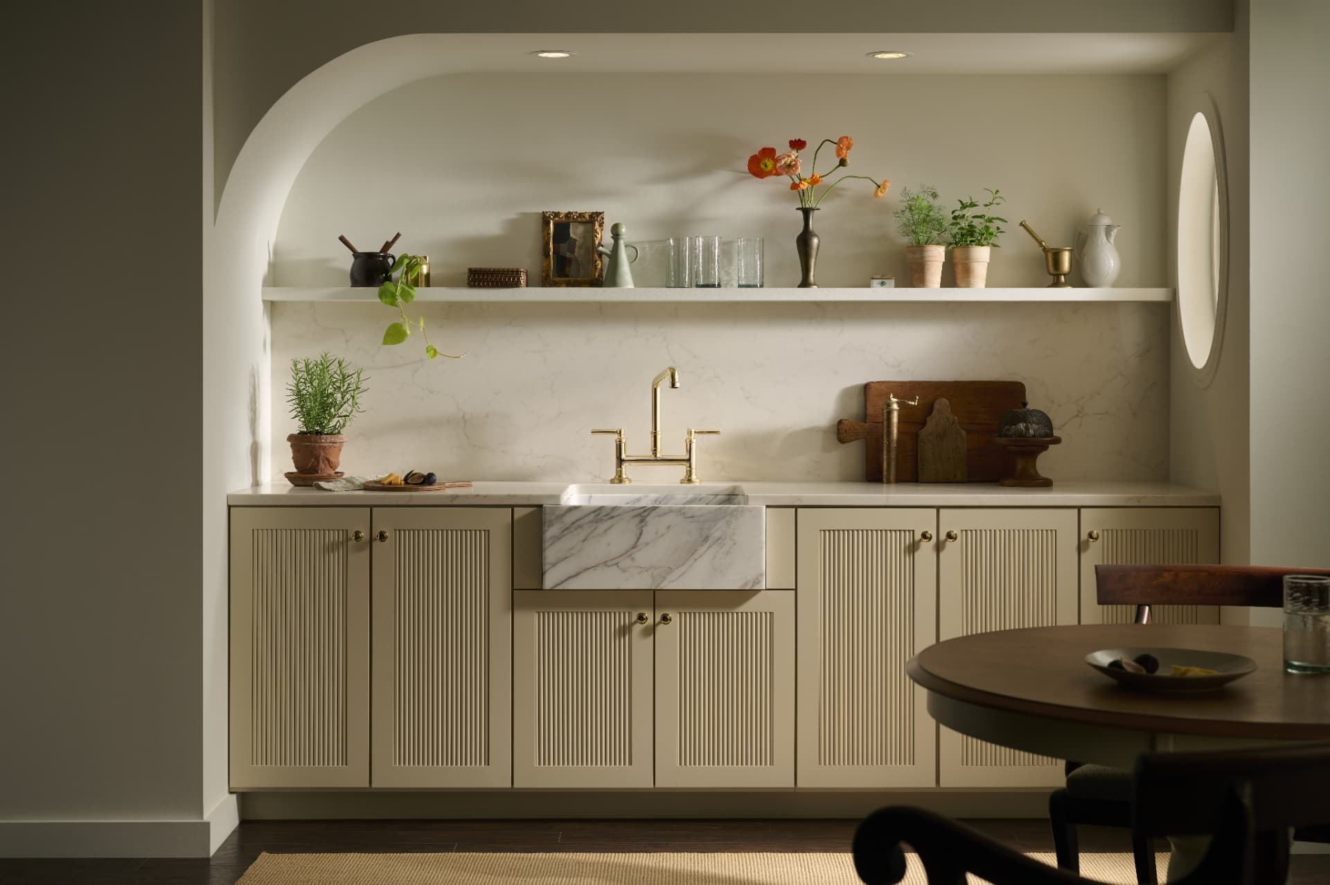 Arched pantry alcove with fluted cabinetry and a marble apron sink